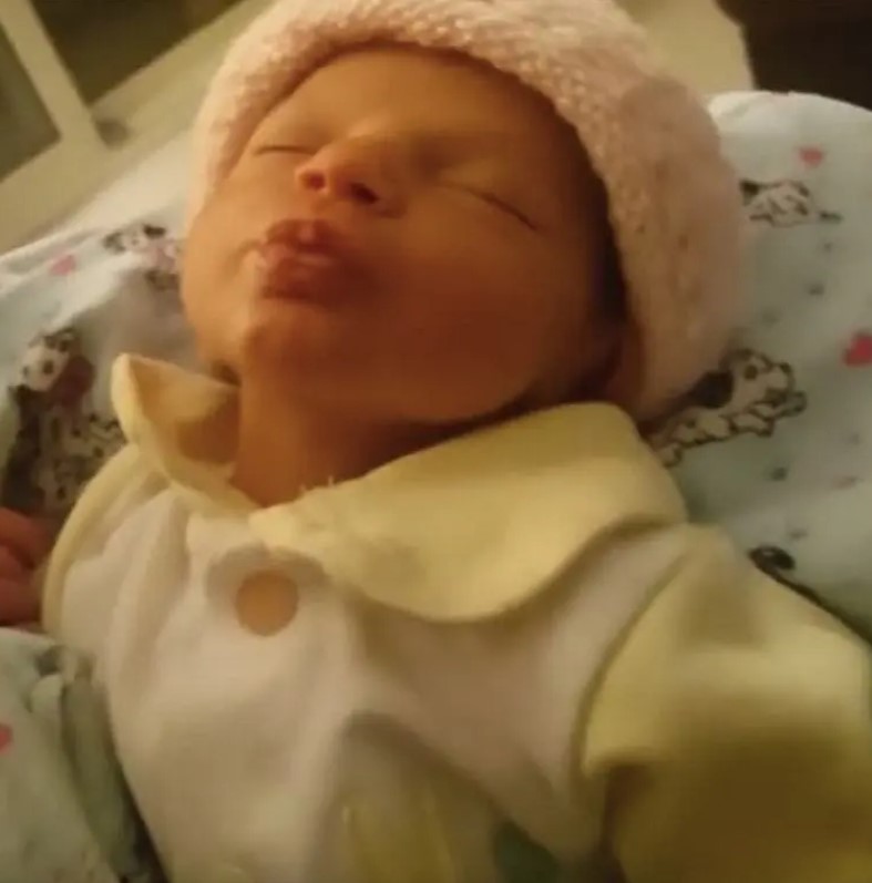 Une maman se penche pour embrasser son nourrisson : Le visage du bébé lui fait chaud au cœur