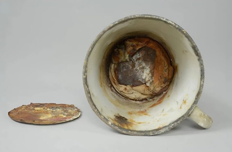 La tasse exposée au musée d'Auschwitz durant 70 ans ; récemment, son fond s'est mis à se décomposer et une cachette a été découverte à l'intérieur