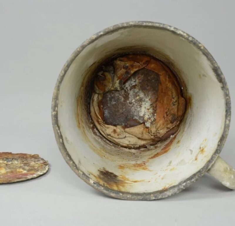 La tasse exposée au musée d'Auschwitz durant 70 ans ; récemment, son fond s'est mis à se décomposer et une cachette a été découverte à l'intérieur