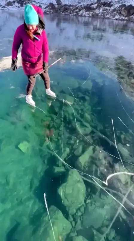 Les patineurs glissent sur le lac transparent de cristal lors d'un phénomène d'une rareté stupéfiante