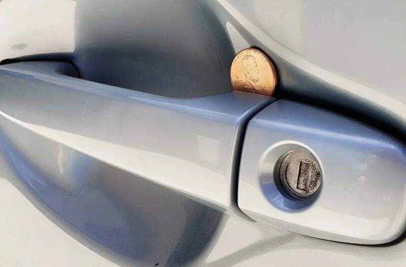 Le matin, j'ai garé mon véhicule sur le parking : en retournant, j'ai aperçu une pièce de monnaie coincée dans la poignée de la portière du passager. Mais qu'est-ce que cela signifie ?